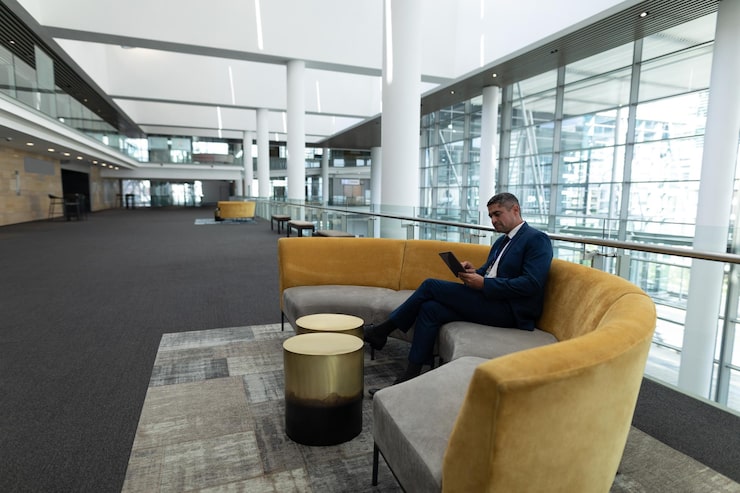 caucasian-businessman-siiting-office-lobby-sofa-touching-his-digital-tablet_13339-374858